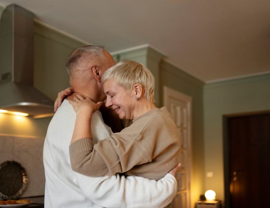 Una pareja mayor se abraza en su casa, tranquilos