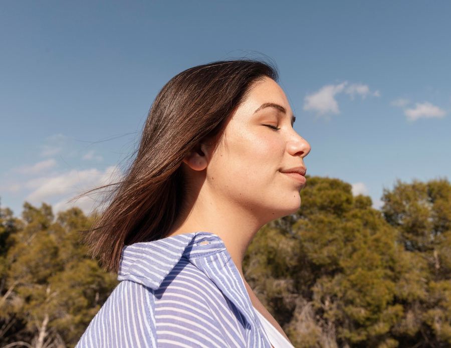 Una mujer disfruta el sol con calma, sin pendientes en la cabeza